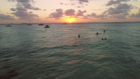 Gente-En-La-Playa-En-Aguas-Turquesas-Del-Caribe-Al-Atardecer