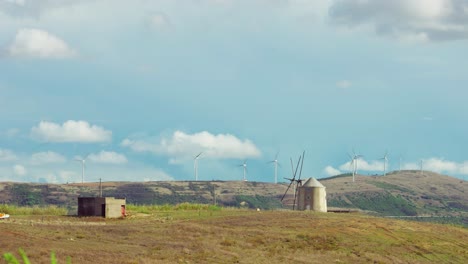 Time-lapse-of-old-windmill,-with-wind-turbines-on-the-background