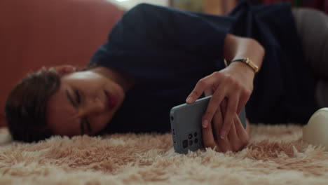 woman laying on the carpet with the phone