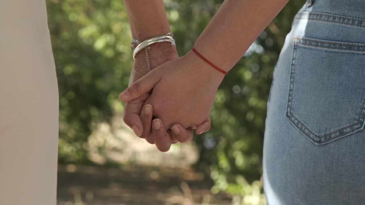 Two People Holding Hands Outdoors