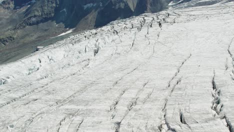 Vista-Aérea-Del-Glaciar-De-Hielo-Derritiéndose-Debido-Al-Calentamiento-Global,-Glaciar-Masivo-Con-Grietas-En-Saas-Fee,-Suiza