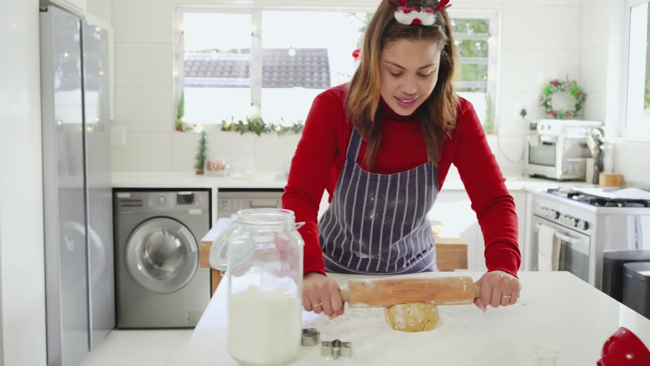 After tapping flour jar, baker in apron dusting countertop, kneading, rolling dough for cookies