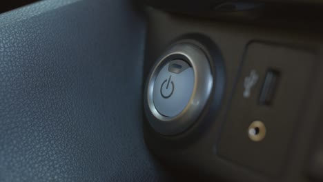 starting and stopping the power of an electric car. female finger pressing an engine start stop button on modern electric car