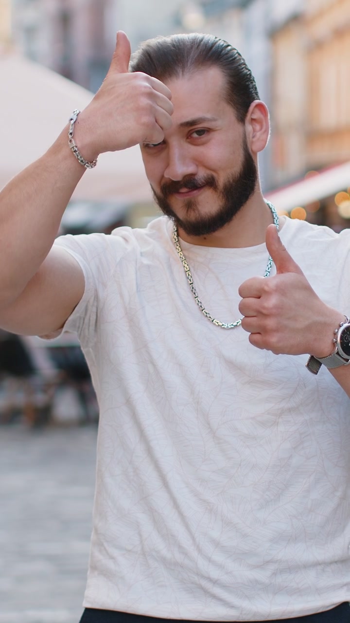 Uomo felice che mostra il pollice in alto come segno positivo qualcosa di buono feedback positivo in strada della città