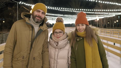 family portrait at the ice rink at night