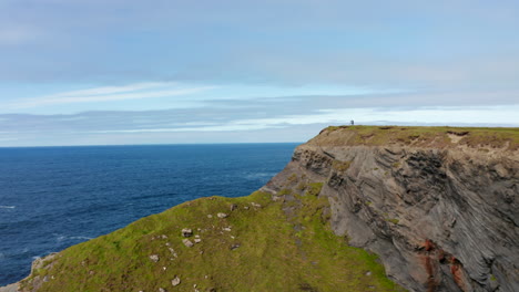 Adelante-Vuela-Sobre-La-Costa-Del-Mar.-Altos-Acantilados-Rocosos-Que-Caen-Abruptamente-Al-Mar.-Revelando-Olas-Rompiendo-En-La-Costa.-Paseo-Del-Acantilado-De-Kilkee,-Irlanda