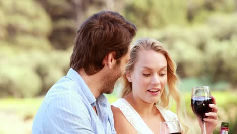 Happy-couple-discussing-and-holding-a-red-wine-glass