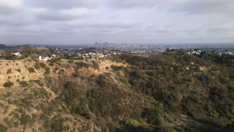 aerial: rising view over hollywood suburb, los angeles city background, 4k view