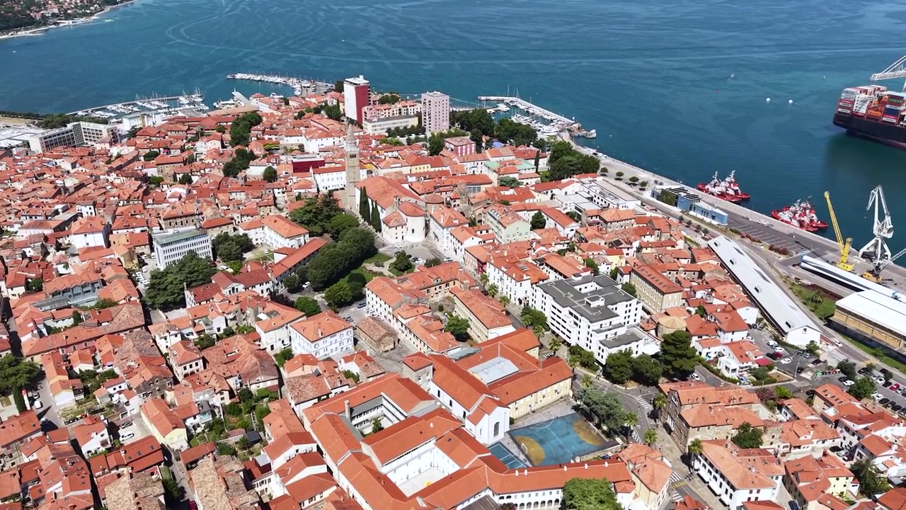 Ripresa con drone degli edifici del centro storico di Capodistria, Slovenia, e della torre della Cattedrale Cattolica Centrale in una calda giornata di sole