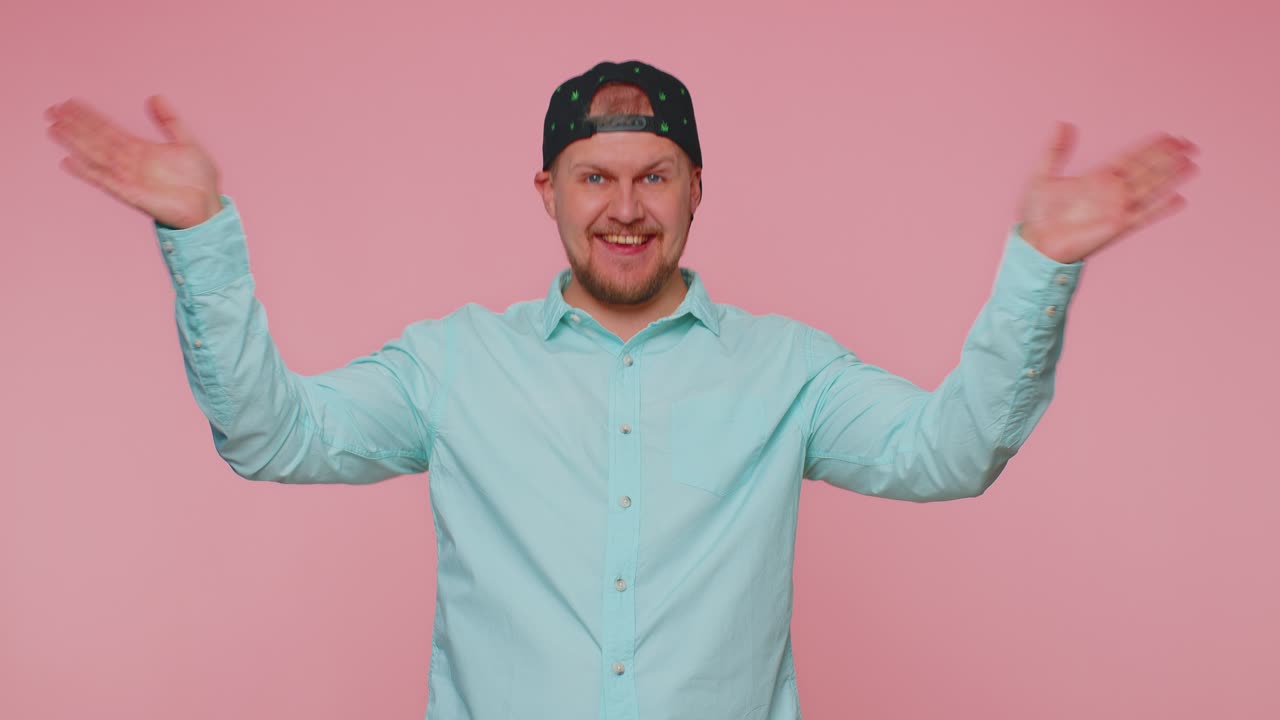 Bearded man smiling friendly at camera and waving hands gesturing hello or goodbye welcoming