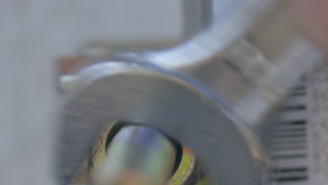 close up of a man using a wrench to tighten a bolt on a water pipe