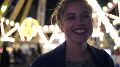 Close-Up-view-of-young-beautiful-happy-girl-with-ponytail-smiling-and-looking-at-camera-hanging-out-in-amusement-park-with