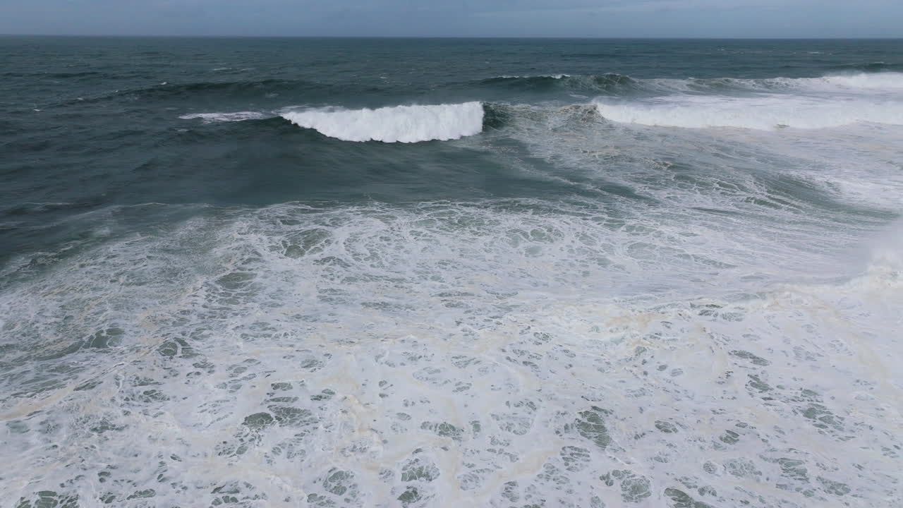 Giant powerful dark blue Atlantic ocean waves at Nazare, Portugal