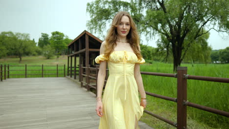 fit young woman walks in ranch or park in countryside by green grass field