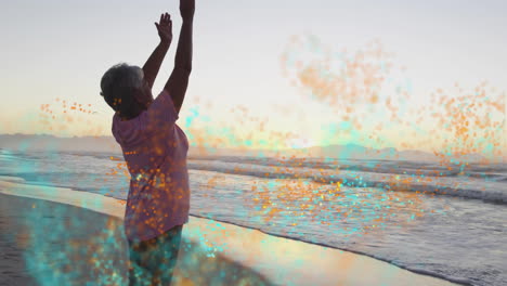 senior woman stretching on beach at sunset, showing health theme with floating turquoise particles
