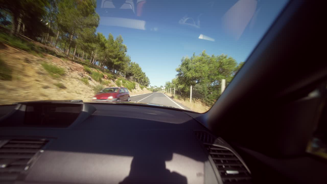 View from inside a car driving on a sunny road