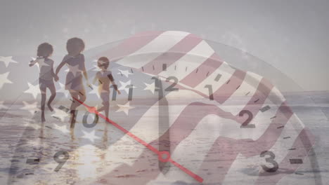 animation of flag of america and clock over african american mother and children walking on beach