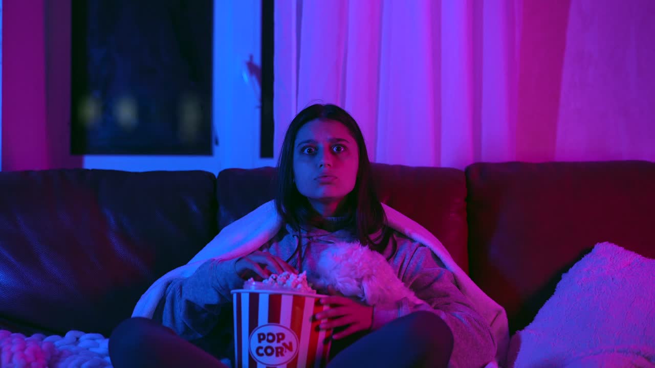 chica viendo una película con perro y palomitas de maíz