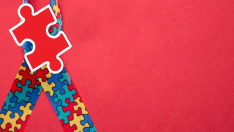 animación de piezas de rompecabezas rojas y amarillas que caen sobre la cinta de concienciación sobre el autismo formada con rompecabezas
