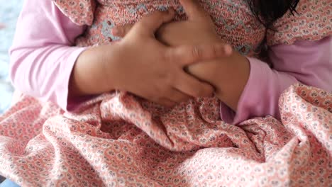 a young girl holding her stomach in pain