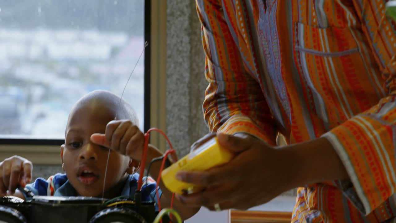 Father and son repairing toy car in a comfortable home 4k
