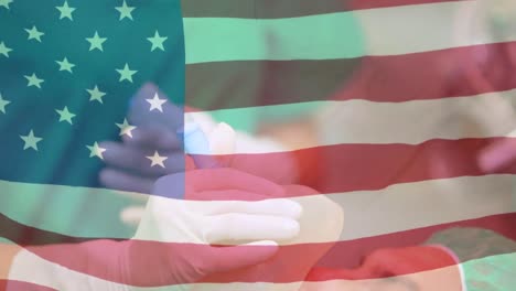 animación de la bandera de los estados unidos con un trabajador de la salud en el fondo durante la pandemia de coronavirus