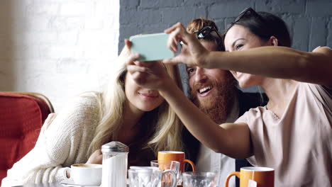 amigos tomando selfies fotografías autorretratos en el café