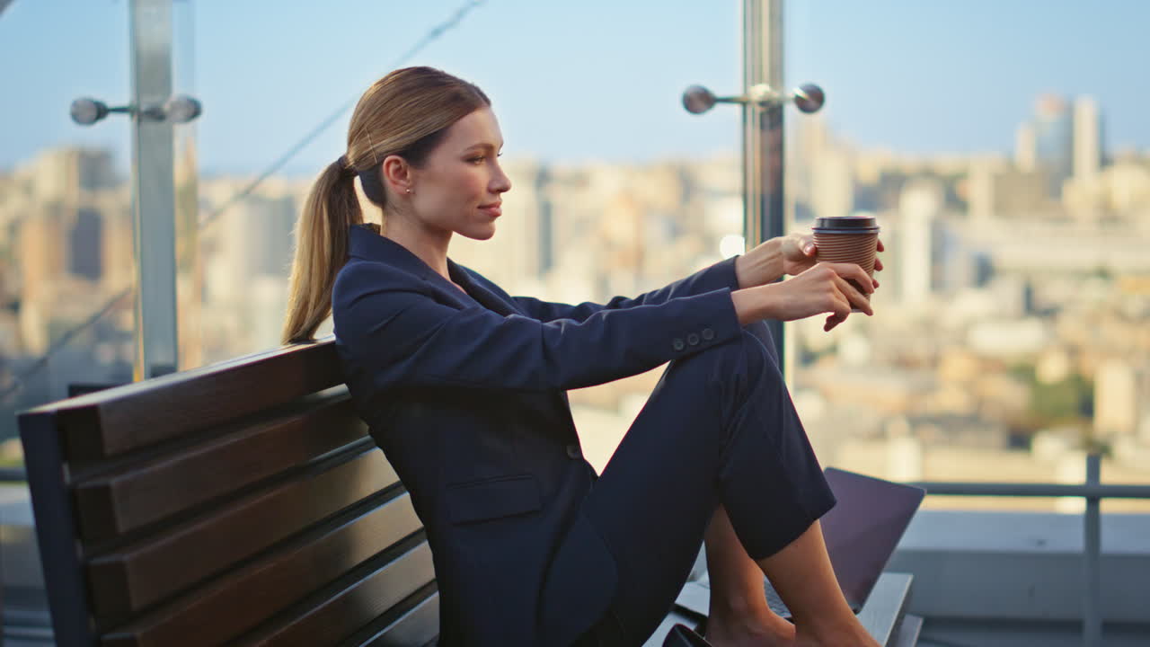 gerente tranquilo tomando un descanso disfrutando del momento en la terraza de vidrio. mujer soñadora sentada