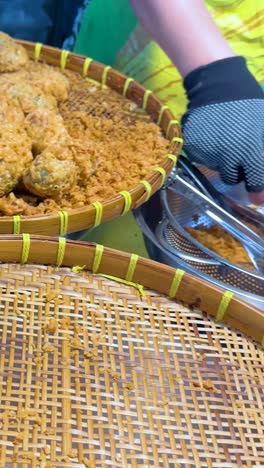 vendor preparing deep fried rice snacks at floating market stall