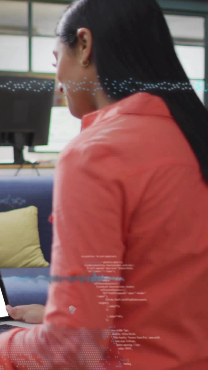 Vertical video: Woman typing laptop while data overlay appearing showing data, man walking with mug