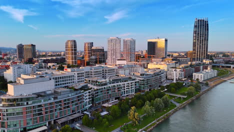 Flight along the waterfront of the Danube with modern buildings. Cityscape of Bratislava, Slovakia at sunset