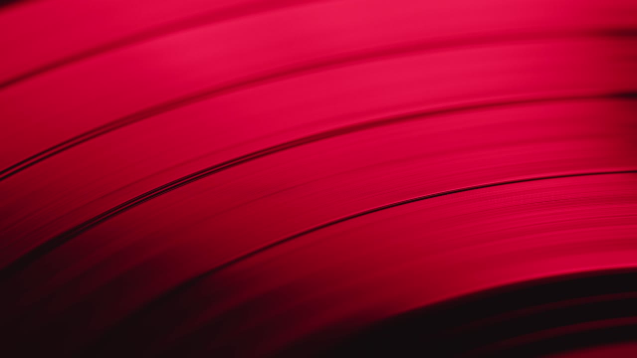 Primo piano astratto di un disco in vinile rosso che gira