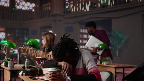 vertical video young adult wakes up black student in university library after falling asleep
