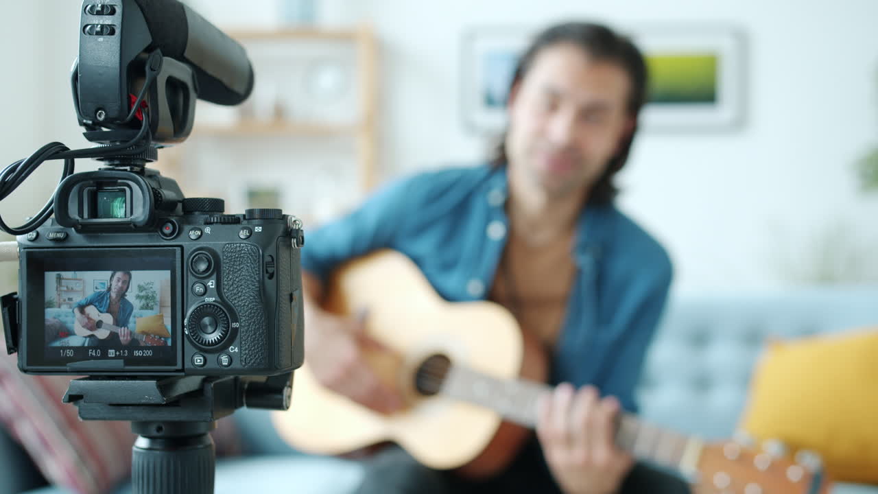 Man Playing Acoustic Guitar for a Video Tutorial/Performance