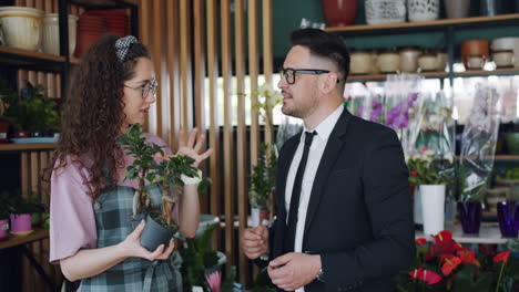 customer and florist looking at bonsai tree in shop