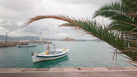 peaceful view of greek port harbour fishing boats with bouritz bay castle