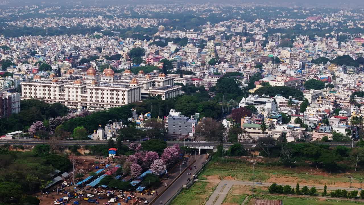 Ospedale JSS con edifici residenziali, alberi e la strada MG a Mysore, Karnataka, India, di giorno, ripresa con avvicinamento, ripresa con drone, 4K