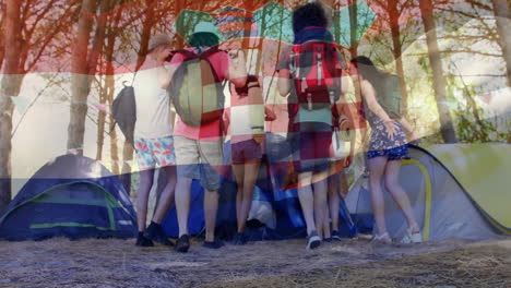 standing near tents, group of friends with backpacks holding croatian flag