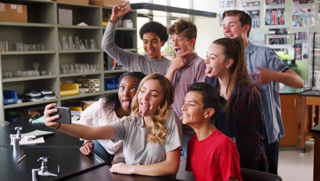 grupo de estudiantes de secundaria tomando selfies en el aula de biología