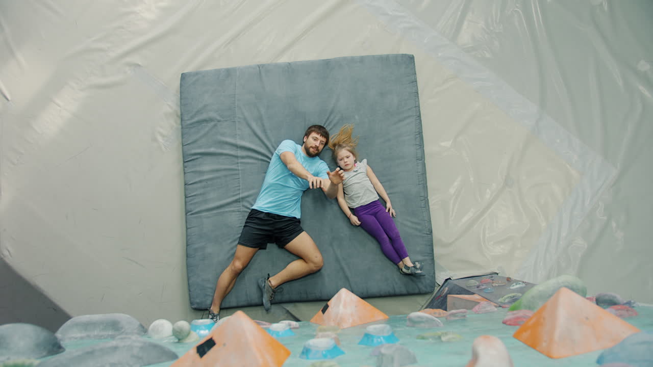 Father teaching daughter rock climbing