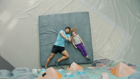 father teaching daughter rock climbing