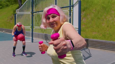 mujer mayor trabajando con pesas en una cancha de baloncesto