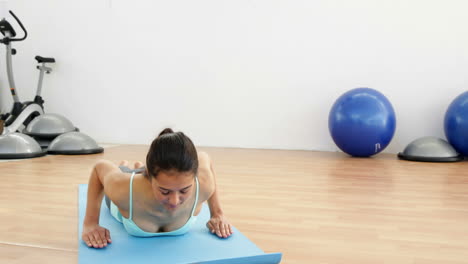 bruneta en forma haciendo yoga en la alfombra de ejercicio