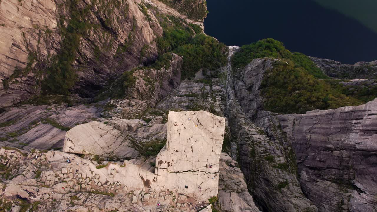 Top down drone footage of iconic Preikestolen Pulpit Rock in Norway. Hikers on the scenic cliff