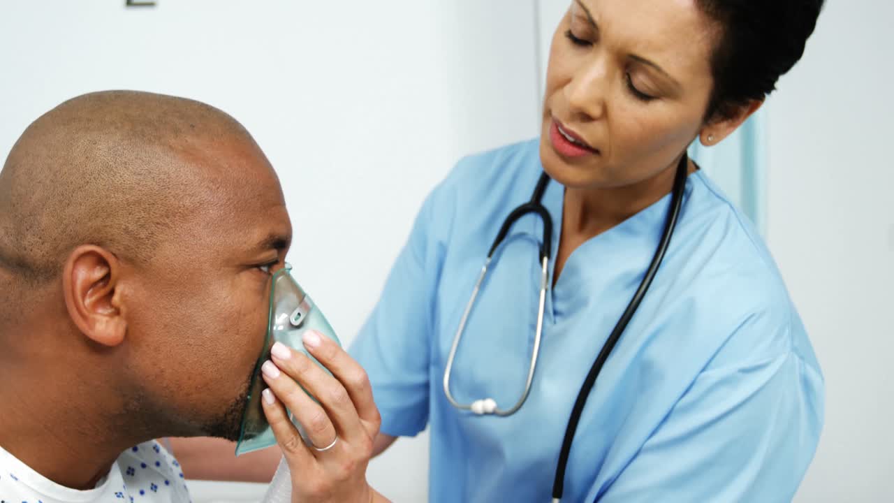 el médico le pone una máscara de oxígeno al paciente.