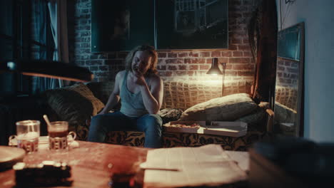 man eating pizza on a couch at night