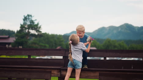 Kleines-Mädchen-Küsst-Seinen-Bruder,-Um-Sich-Für-Die-Blume-Auf-Dem-Boden-Zu-Bedanken