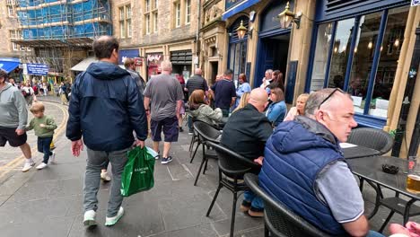 crowded street with people enjoying outdoor dining