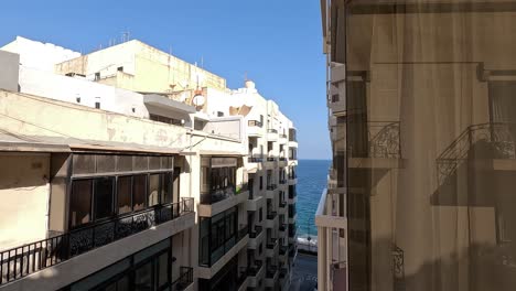 A-rotating-view-along-the-streets-of-Malta,-revealing-a-passage-with-a-sea-view