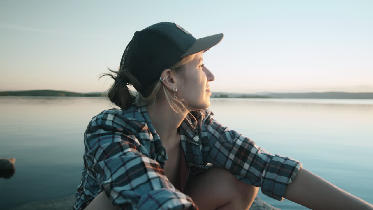 Donna seduta vicino al lago di sera